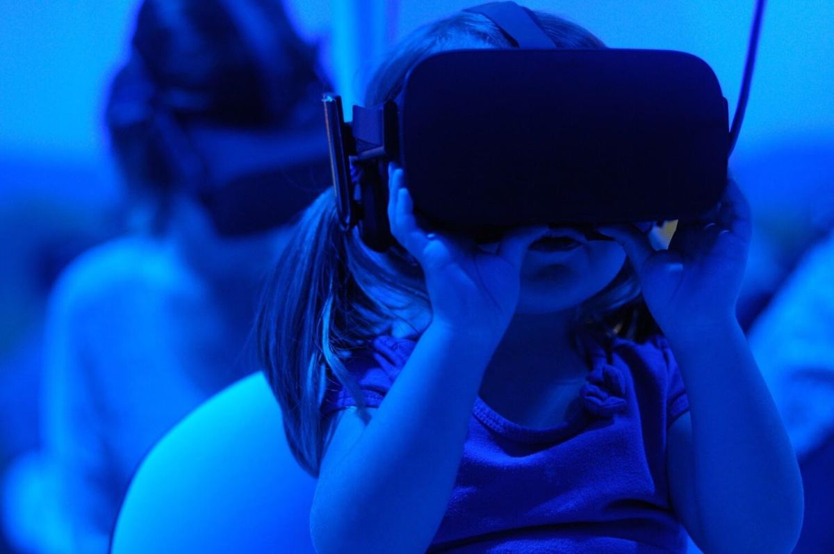 A child wearing a VR headset in blue light